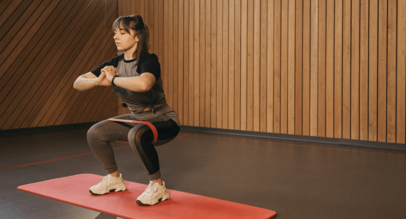 Squat position with the hip band. Many types of squats can be done with hip bands like split squats, goblet squats, box squats, air squats- CCB