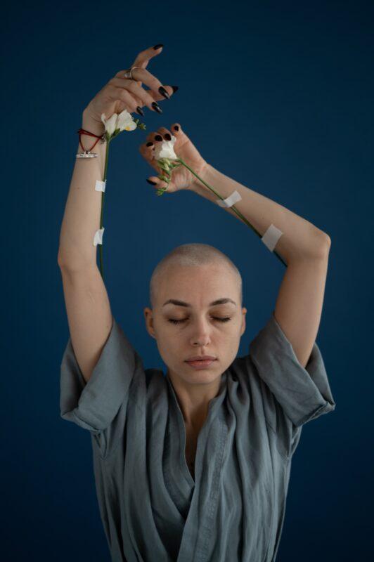 Hair growth after chemo all you need to know: Photo by SHVETS production: https://www.pexels.com/photo/mindful-woman-with-blooming-flowers-and-raised-arms-6984597/